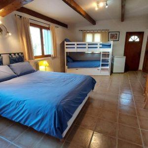 a bedroom with a blue bed and a bunk bed at le Mas Provençal in Régusse