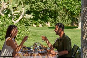 un hombre y una mujer sentados en una mesa con copas de vino en Agapi Beach Resort Premium All Inclusive, en Amoudara Herakliou