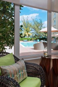 a patio with a wicker chair and a table and a pool at Courtyard by Marriott Nassau Downtown/Junkanoo Beach in Nassau
