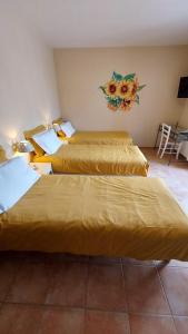 two beds in a hotel room with yellow sheets at le Mas Provençal in Régusse