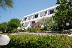 a white building with flowers in front of it at Hippocampus Hotel in Naousa