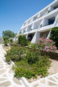 a building on the beach with flowers in front of it at Hippocampus Hotel in Naousa