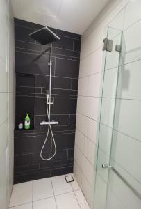 La salle de bains est pourvue d'une douche et d'un mur noir. dans l'établissement Anggun Residence KL Malaysia, à Kuala Lumpur