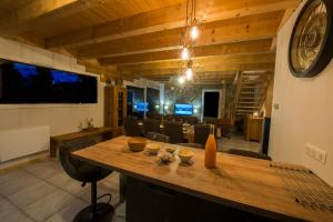 uma sala de jantar com uma grande mesa de madeira e cadeiras em Chalet proche des pistes de ski avec vue et spa em Gérardmer