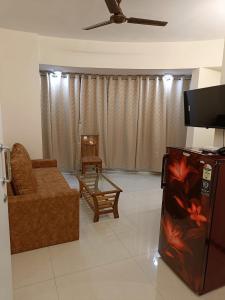 a living room with a couch and a tv at Hotel Charaksanjivani in Navi Mumbai