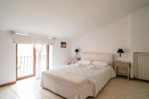 ヴェローナにあるAppartamento Scaligero Borgo Trentoの白いベッドルーム(大型ベッド1台、窓付)