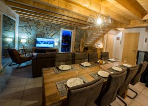uma sala de jantar e sala de estar com mesa e cadeiras em Chalet proche des pistes de ski avec vue et spa em Gérardmer