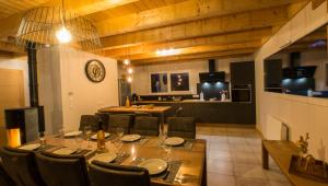 uma sala de jantar com mesa e cadeiras e uma cozinha em Chalet proche des pistes de ski avec vue et spa em Gérardmer