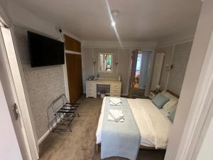 劍橋的住宿－Cambridge Bed & Breakfast，一间卧室配有一张床、一张书桌和一台电视