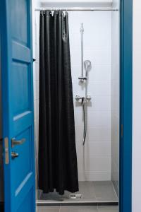 eine Dusche mit einem schwarzen Duschvorhang im Bad in der Unterkunft Sniegi Apartments with sauna in Madona