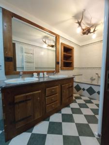 baño con 2 lavabos y suelo a cuadros en La Randoulino, en Pomaretto