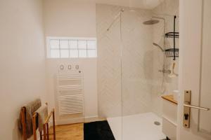 a white bathroom with a shower and a table at Sous le Saule, entre lac et océan in Naujac-sur-Mer +14 photos