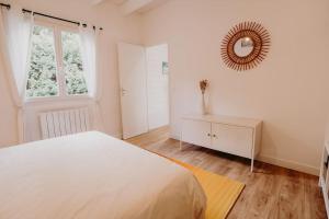 a bedroom with a large white bed and a mirror at Sous le Saule, entre lac et océan in Naujac-sur-Mer