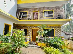 een huis met een balkon en planten ervoor bij St. Anthony guest house. in Anjuna