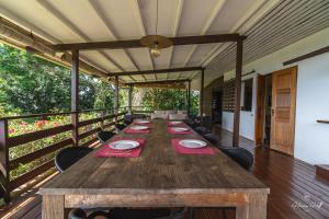 a long wooden table on a deck with chairs at Horizon Hill Villa in Pirae