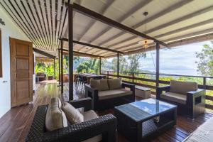 a patio with furniture and a view of the ocean at Horizon Hill Villa in Pirae