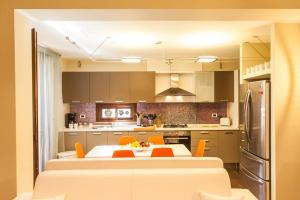 eine Küche mit einem Tisch und orangefarbenen Stühlen in der Unterkunft Villa Lidia in Balestrate