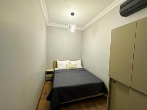 Habitación pequeña con cama y lámpara de araña. en Sisli House By Remar Holding en Estambul