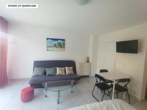 a living room with a couch and a table at Studio Quiétude in Saint-Aygulf