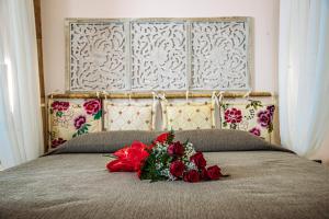 a bouquet of red roses sitting on a bed at Suite Dreams Montecatini in Montecatini Terme