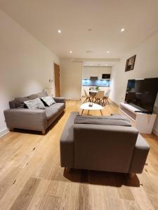 a living room with two couches and a flat screen tv at Kaf Luxury Apartment in London