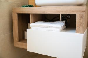 baño con lavabo y toallas en un estante en Il casalicchio for couples, en Montalbano