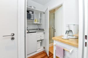 a kitchen with white cabinets and a counter top at Haus Bene-Vivere / OG-Appartement in Westerland