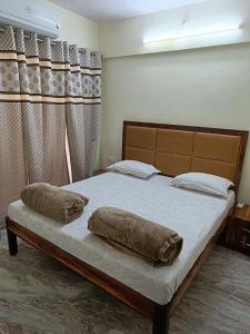 Hotel Charaksanjivani في نافي مومباي: غرفة نوم عليها سرير ووسادتين