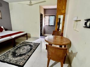 um quarto com uma mesa e cadeiras e uma cama em St. Anthony guest house. em Anjuna