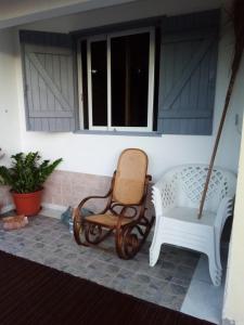 a porch with two rocking chairs and a swing at Chez Vava et Maïanne in Bouillante