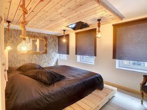 ein Schlafzimmer mit einem großen Bett in einem Zimmer mit Fenstern in der Unterkunft L'ancre céleste in Aywaille