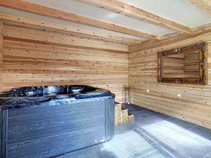 a sauna with a stove in a wooden wall at L'ancre céleste in Aywaille