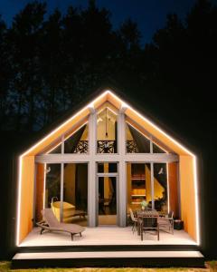 Una casa con luces en la parte delantera. en Sniegi design cabin with sauna en Madona