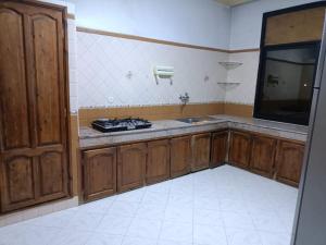 a kitchen with wooden cabinets and a sink and a tv at Villa à la décoration marocaine in Rabat
