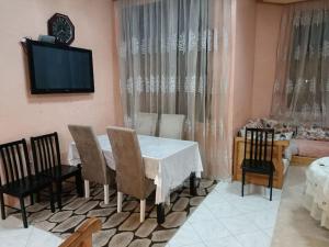 Villa à la décoration marocaine في الرباط: غرفة طعام مع طاولة وكراسي وتلفزيون