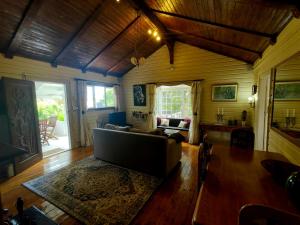 een woonkamer met een bank en een tafel bij Swiss Cottage Guest House in Kaapstad