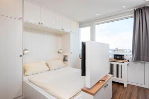 a white room with a large window and a couch at Exklusive Wohnung im Herzen Westerlands in Westerland