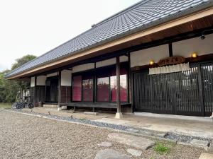 um edifício com janelas pretas e vermelhas e uma cerca em GOEMON The Last Japan 