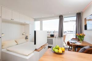 a kitchen and living room with a table and a couch at Exklusive Wohnung im Herzen Westerlands in Westerland