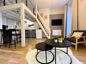 a living room with a table and a staircase at Montagn'Art Studio. 4pers 30m2. Coeur village. in Cauterets