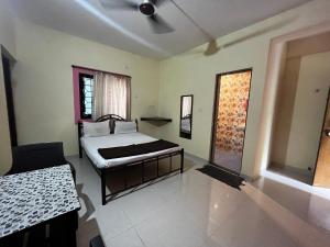 een slaapkamer met een bed en een raam erin bij St. Anthony guest house. in Anjuna