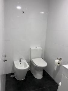 La salle de bains blanche est pourvue de toilettes et d'un lavabo. dans l'établissement Estoril - Bay view apartment, à Estoril