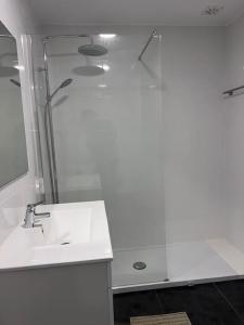 La salle de bains blanche est pourvue d'un lavabo et d'une douche. dans l'établissement Estoril - Bay view apartment, à Estoril