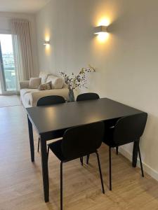 - une table et des chaises noires dans le salon dans l'établissement Estoril - Bay view apartment, à Estoril