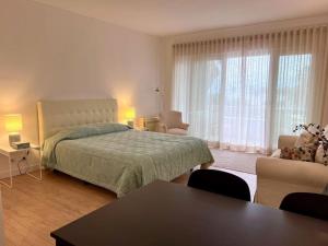 - une chambre avec un lit, une table et des chaises dans l'établissement Estoril - Bay view apartment, à Estoril