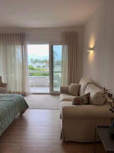 - un salon avec un canapé et une fenêtre dans l'établissement Estoril - Bay view apartment, à Estoril