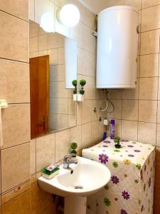 uma casa de banho com um lavatório, um espelho e uma mesa em Tony's Downtown vintage apartment em Skopje