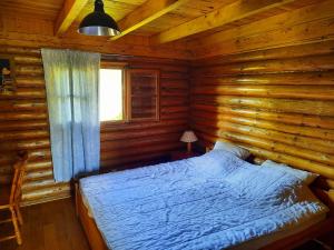 a bedroom with a bed in a log cabin at CHALET RONDIN JURA in Aromas