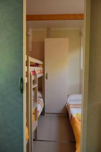 um pequeno quarto com 2 beliches e um corredor em Bungalows, Camping Vega de Francia em Sotoserrano