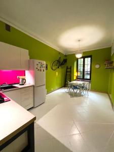 a kitchen with green walls and a white refrigerator at Old Cracow Style in Krakow